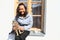 Smiling tropical girl with cat on windowsill