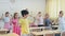 Smiling tweenager pupils doing little warm-up in class with female teacher at lesson in elementary school