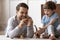 Smiling two generations male family playing with dinosaurs at home.