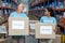 Smiling two volunteers holding a donations box