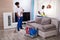 Smiling Two Young Male Janitor Cleaning The Living Room