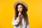 Smiling ukrainian woman holding finger on lips, yellow studio background.