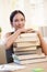 Smiling university student with pile of books