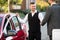 Smiling Valet And Businessperson Standing Near Car