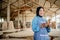 smiling veiled businesswoman holding a cell phone in a woodcraft shop