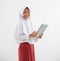 smiling a veiled girl in elementary school uniform stands holding a digital tablet