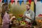 Smiling vendor offering tomatoes to woman at the counter