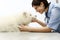 Smiling Veterinarian examining dog on table in vet clinic