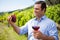 Smiling vintner holding grapes and glass of wine