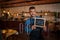 Smiling waiter holding chalkboard with open inscription in cafe