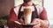 Smiling waiter holding glass of cold coffee in cafe