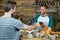 Smiling waiter receiving credit card of customer for payment at counter