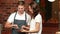 Smiling waiter using tablet with a customer