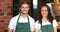 Smiling waiter and waitress gesturing thumbs up