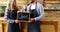 Smiling waiter and waitresses holding open sign board