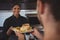 Smiling waitress giving plate with food to coworker