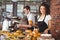 Smiling waitress holding bread roll with tong