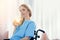 Smiling wheelchair woman holding glass of water