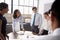 Smiling white female manager listens to team in meeting room