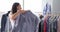 Smiling woman administrator in dry cleaner hangs clothes on hanger closeup