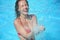 Smiling woman bathes in pool under water splashes