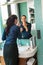 Smiling woman bathroom applying lipstick mirror businesswoman