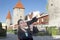 The smiling woman with the camera photographs old city wall towers. Tallinn, Estonia