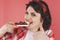 Smiling woman with chocolate in a red studio.