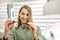 Smiling woman choosing new optical glasses to buy in optics store