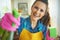 Smiling woman with cleaning agent and sponge housecleaning