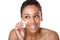 Smiling woman cleaning face with make up sponge