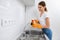 Smiling woman cleaning faucet kitchen sink.