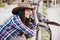 Smiling woman cowgirl leaning on fence in village