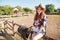 Smiling woman cowgirl standing and using mobile phone on ranch