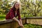 Smiling woman cutting harvest of green parsley in open greenhouse in country garden