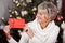 Smiling woman displaying a red Christmas voucher