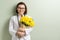 Smiling woman doctor with bouquet