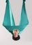 Smiling woman doing aerial yoga in mid air