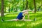 Smiling woman doing splits on green grass