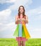 Smiling woman in dress with many shopping bags