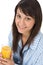 Smiling woman drink orange juice in pajamas