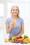 Smiling woman drinking fruit juice at home