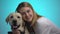 Smiling woman embracing cute labrador dog, looking at camera, pet is best friend