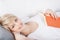 Smiling woman enjoying a book on the sofa