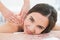 Smiling woman enjoying shoulder massage at beauty spa