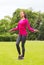 Smiling woman exercising with jump-rope outdoors