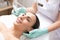 Smiling woman having her skin cleaned with modern tool