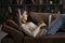 Smiling woman in headphones relax on sofa with laptop