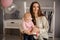 Smiling woman and her cute little daughter holding a present