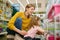 Smiling woman with her daughter choosing hamster or other rodent at pet shop